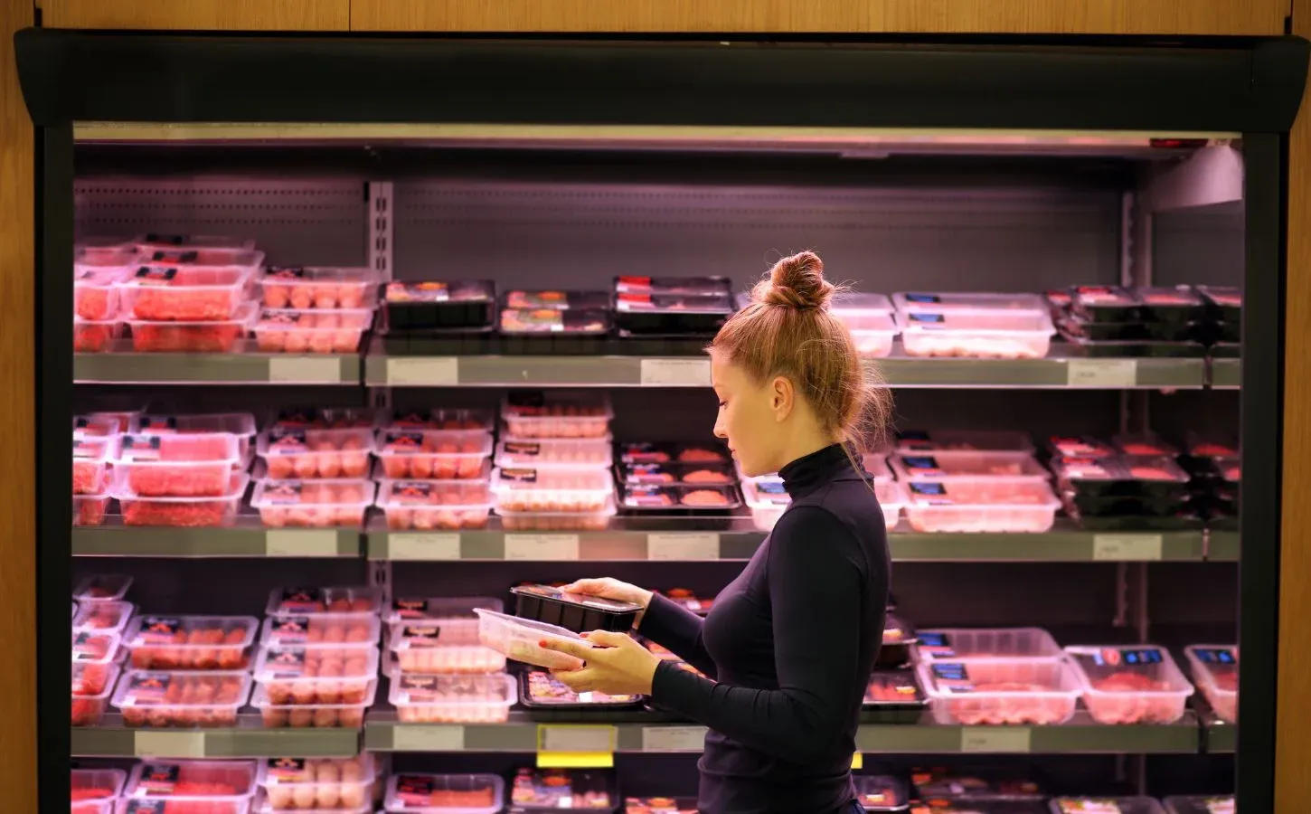 A woman shops for meat at a supermarket.