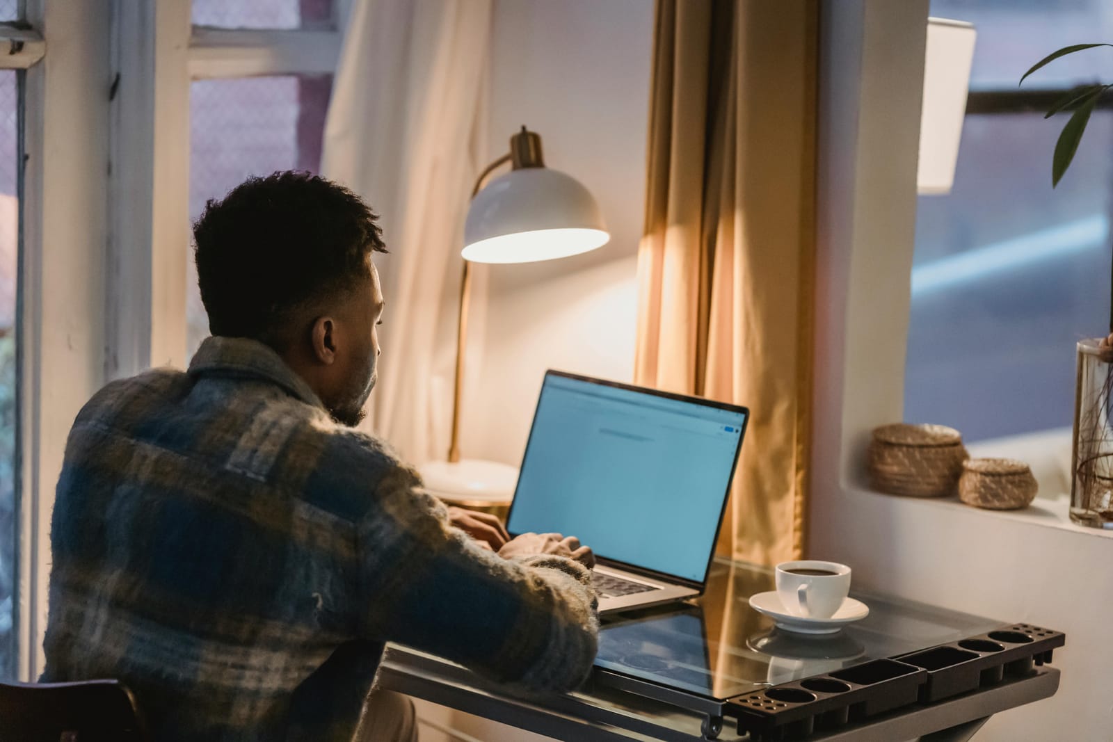 Focused man using laptop in evening at home